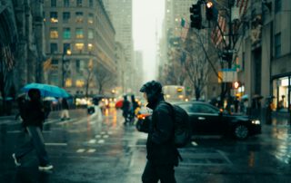 Photo by Lerone Pieters unsplash.com/photos/a-man-walking-across-a-street-holding-an-umbrella-MYjucYkrTUY