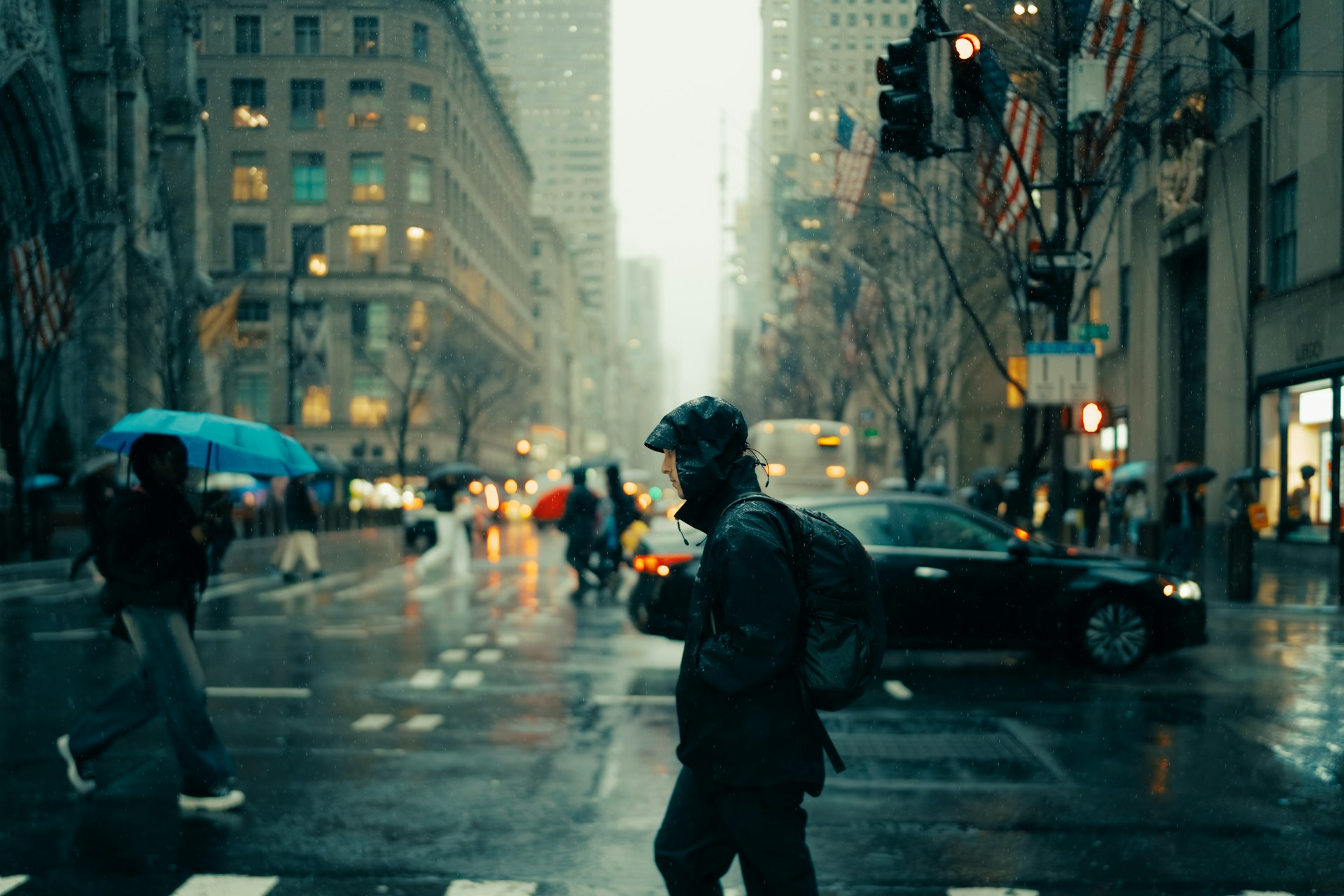 Photo by Lerone Pieters unsplash.com/photos/a-man-walking-across-a-street-holding-an-umbrella-MYjucYkrTUY
