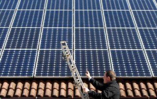 A man in Germany examines the solar panels on his roof, making power he can resell at an excellent financial return. Germany recently installed more solar cells in a single month than the United States did in all that year. (Reuters)
