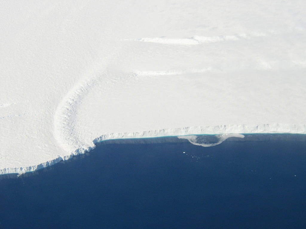 This photo shows the ice front of the ice shelf in front of Pine Island Glacier, a major glacier system of West Antarctica. The image was taken during the NASA/Centro de Estudios Cientificos, Chile (CECS) Antarctic campaign of Fall 2002. Image credit: NASA/JPL-Caltech/UC Irvine