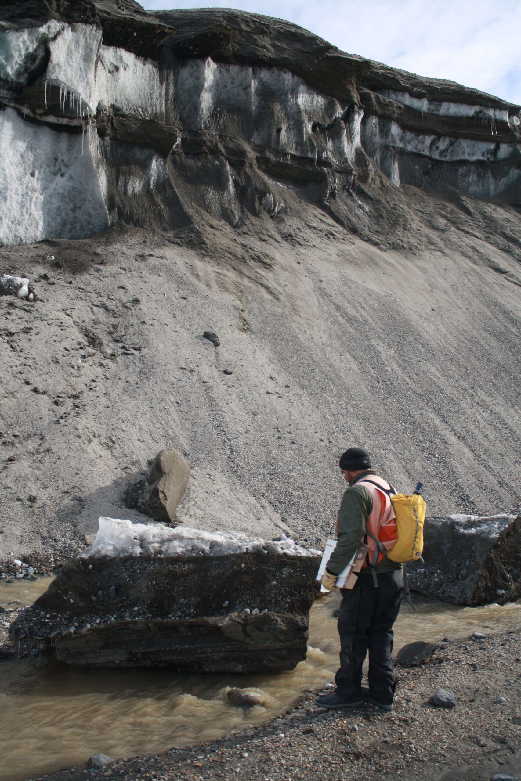 Research team member Jim O'Connor of the USGS inspects a block of ice calved off the Garwood Valley ice cliff. Photo by Joseph Levy, University of Texas Institute for Geophysics.