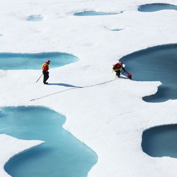 Researchers collect water samples from the Arctic ocean sea ice regions.